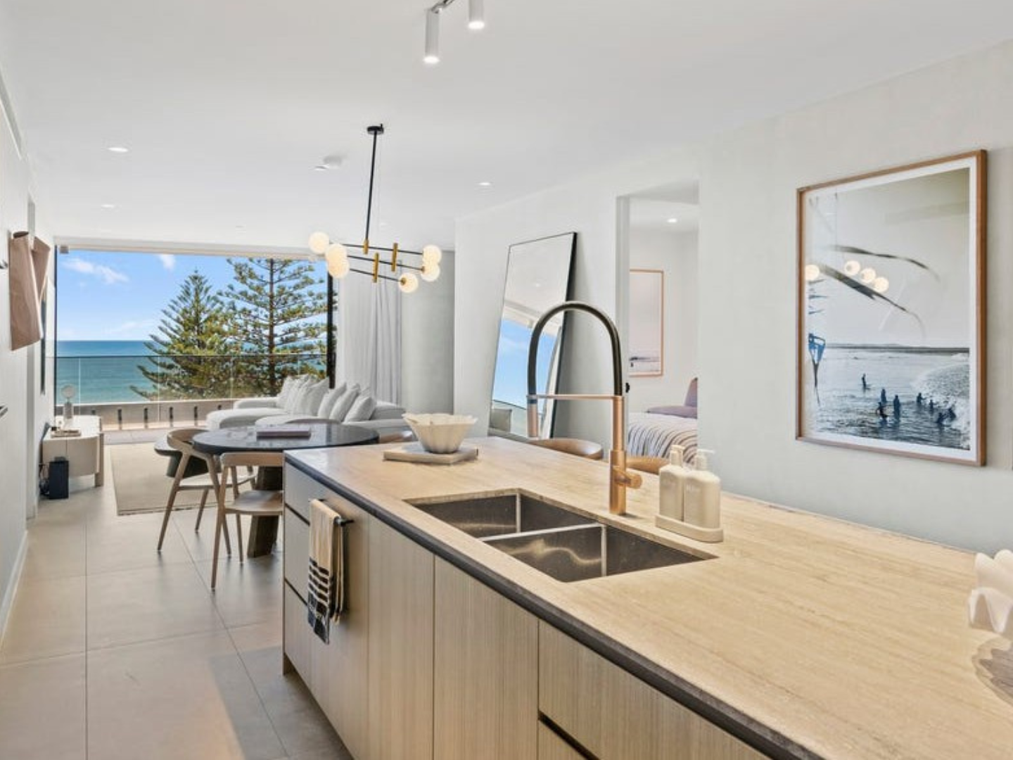 Modern kitchen with a view of the ocean and large photographic wall art hired for property styling in Mondrian Residences Burleigh Heads