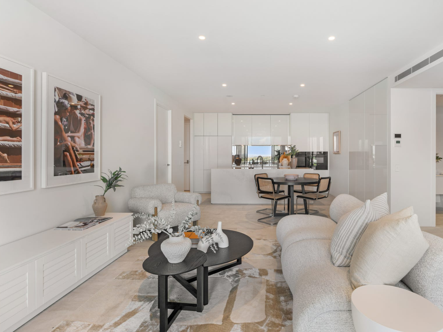 Modern living room with white furniture and decor in Burleigh Heads with Slim Aarons artwork hired for property styling