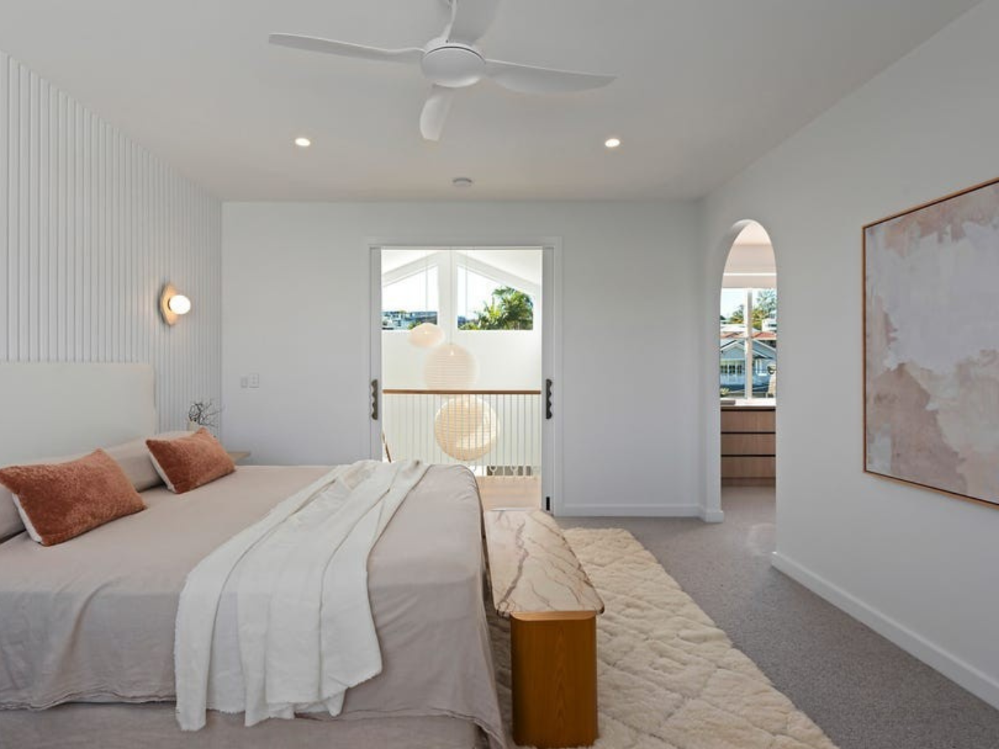 Modern bedroom with a bed, bench, and large artwork on wall used as property styling with art hire