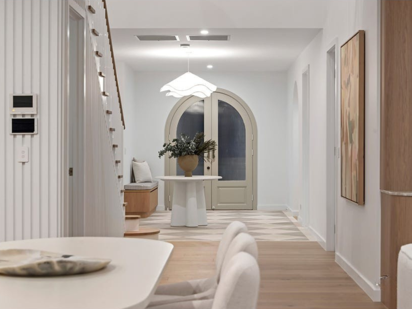 Modern interior design of a hallway with a staircase and decorative elements including art for hire used for property styling. 